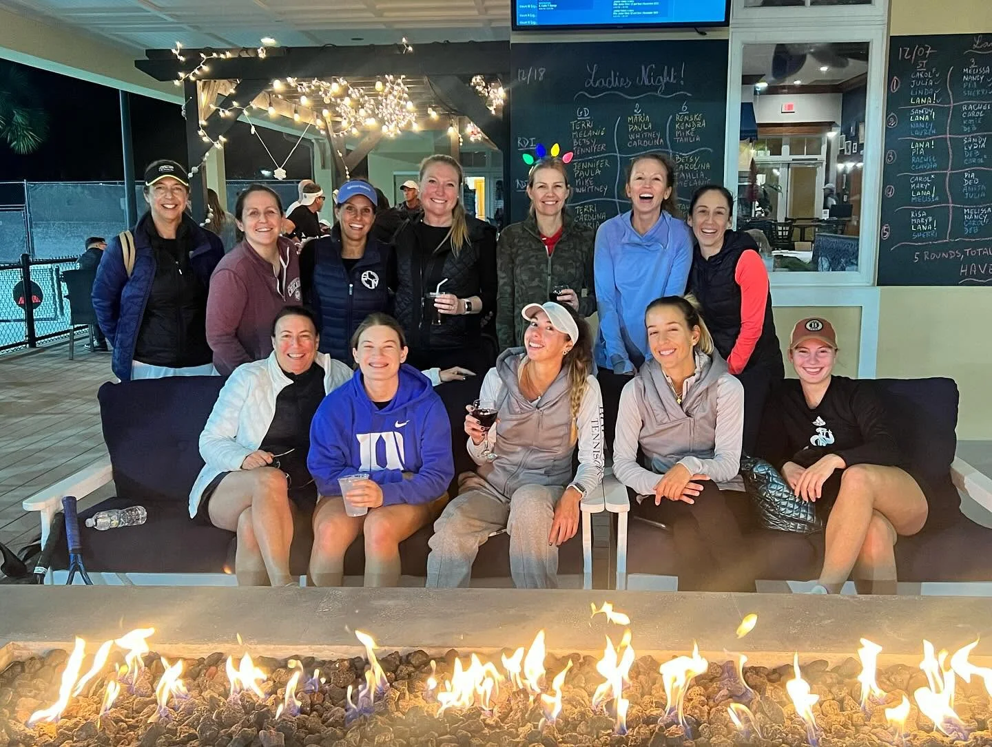 Boulevard members gathering around the fire pit at Boulevard Tennis and Padel Club
